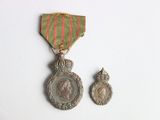 deux médailles et une médaille sur une surface blanche