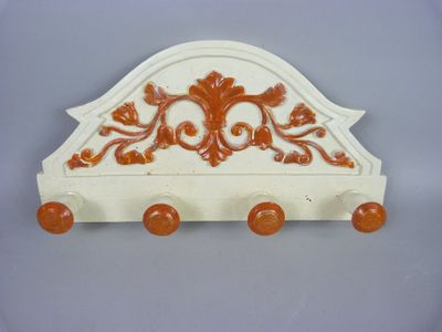 une photo d'un porte-manteau blanc et orange avec des boutons orange