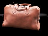an image of a brown leather bag on a black background