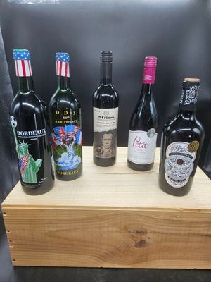 six bouteilles de vin sont alignées sur une caisse en bois