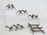 Plusieurs figurines représentant des chevaux et des chiens sont exposées sur une étagère transparente.