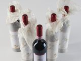 several bottles of wine wrapped in plastic wrappers on a white surface
