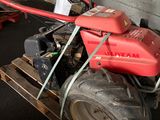 a small red tractor with a big tire on a pallet