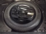 a tire in the trunk of a car with a flat tire