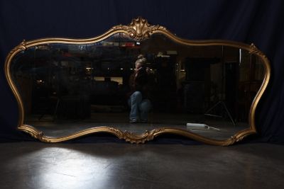 un homme en train de se prendre en photo dans un grand miroir
