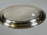 a silver plate with a silver lid on a table
