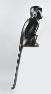 sculpture représentant un singe assis sur ses pattes arrière sur une surface blanche
