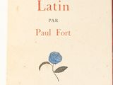 an old book with a blue rose on it sitting on top of a table