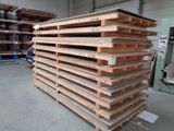 a large stack of wooden pallets in a warehouse