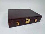 a small wooden box with gold handles on a white surface