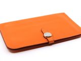 un portefeuille en cuir orange muni d'un fermoir métallique