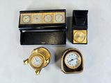 three clocks and a box on a white surface