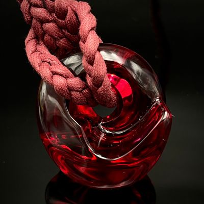 un vase en verre rouge orné d'un nœud