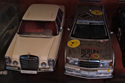 trois petites voitures exposées dans une vitrine