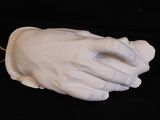 a white statue of a hand holding a string