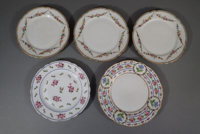 four plates with floral designs are arranged on a gray surface