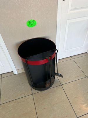 a black trash can sitting on the floor next to a white door