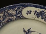 a blue and white plate with a bird on it
