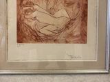 framed drawing of a woman laying down on a bed in a room
