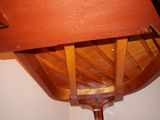a wooden chair with a wooden seat underneath a wooden table