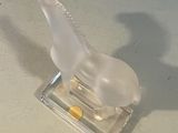a small plastic animal that is sitting on a glass block
