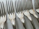 six forks that are sitting on a table