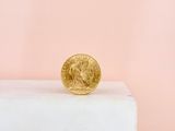 a gold coin sitting on top of a white pedestal