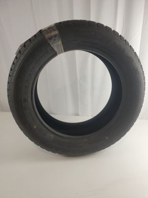 a close up of a tire on a white surface with a curtain in the background