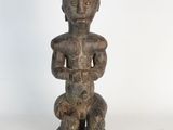 a close up of a statue of a person sitting on a table
