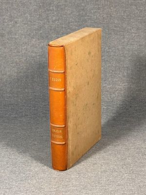 an old book sitting on top of a table next to a gray wall