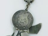 a silver coin with a knife on it on a keychain