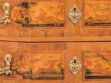a wooden chest of drawers with a painting on it
