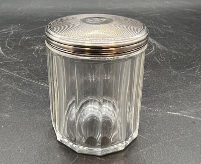 un bocal en verre muni d'un couvercle, posé sur une table