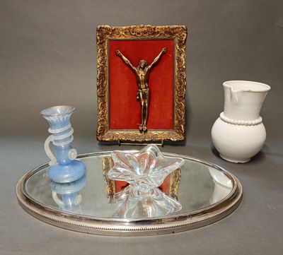 un plateau en argent sur lequel repose un crucifix, à côté de deux vases et d'un miroir