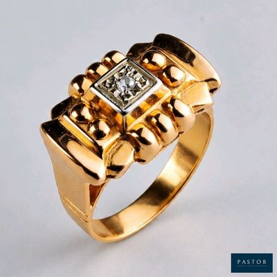 gros plan d'une bague en or avec un diamant au centre