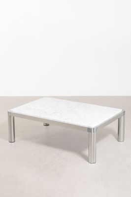 une table basse en marbre blanc posée sur un sol en béton
