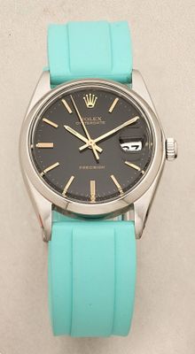 a close up of a watch on a white surface with a blue strap