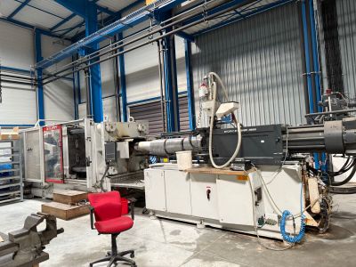 une photo d'un atelier d'usinage avec une chaise rouge devant