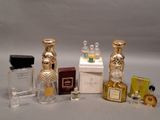 plusieurs flacons de parfum posés sur une table à côté d'une boîte de parfum