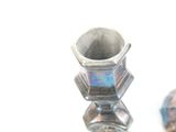 two silver candlesticks sitting next to each other on a table