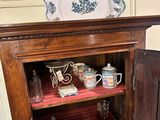 a wooden cabinet with plates and cups on it