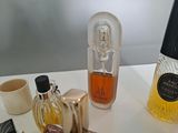 bottles of perfumes are sitting on a table next to a cup of coffee