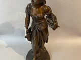 bronze figurine of a girl holding a basket of flowers
