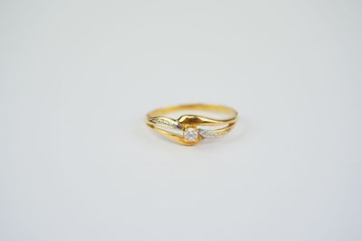 a gold ring with two diamonds on it