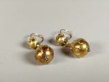 a pair of gold earrings on a white surface