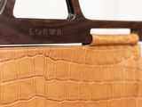 the brown leather handbag is hanging on the wall