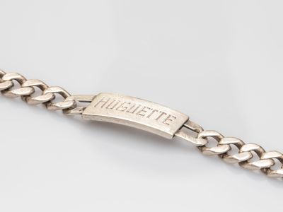 a close up of a silver bracelet on a white surface