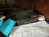 un ordinateur portable posé sur un bureau, à côté d'une pile de papiers