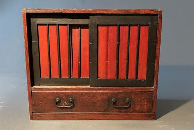 une image représentant un petit meuble en bois aux portes rouges et noires