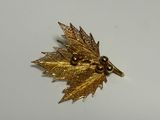 une broche en feuille d'or ornée de perles